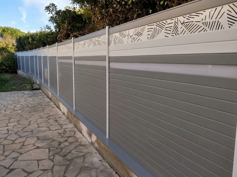 Clôture extérieure moderne longeant une allée en pierre naturelle irrégulière