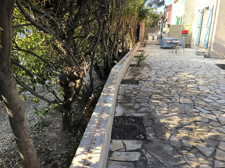 Allée extérieure dallée en pierres naturelles irrégulières (opus incertum), bordée d'une bordure en bois de plantation neuve