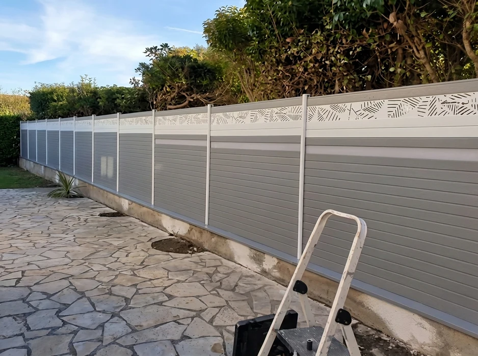 Terrasse extérieure en dallage irrégulier de pierre naturelle calcaire, longeant une piscine couverte d'une bâche hivernale